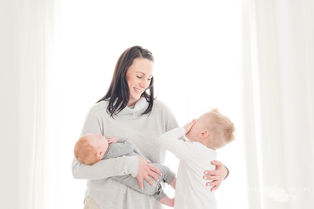 little boy covers his face as he laughs and mama smiles at him in niagara