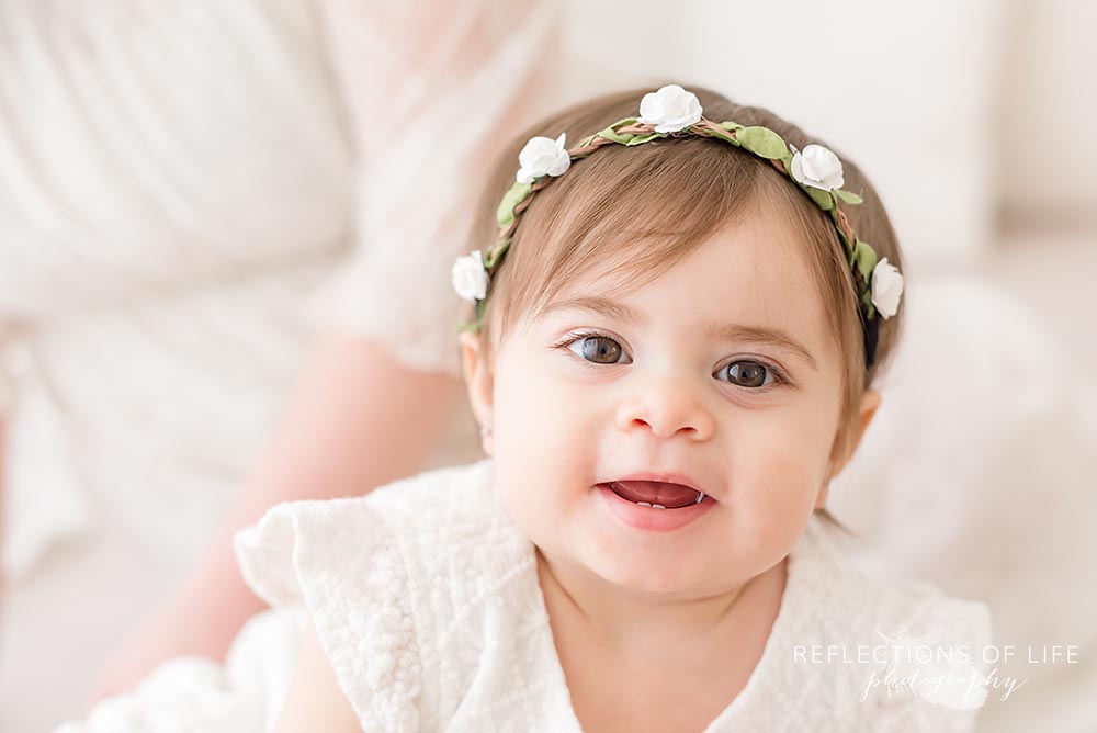 baby giggles at the camera in natural light studio