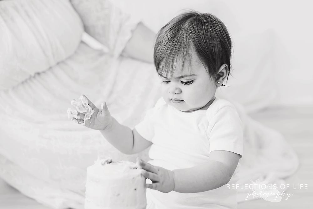 little girl gets messy with her cake in black and white