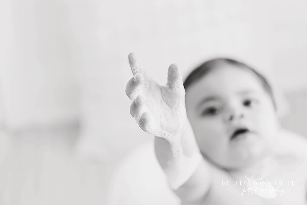 closeup of baby's hand reaching up in black and white
