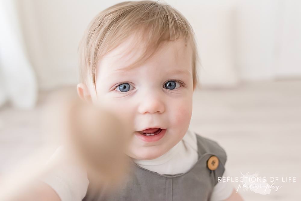 baby looks at his toy as he tries to show the camera in grimsby