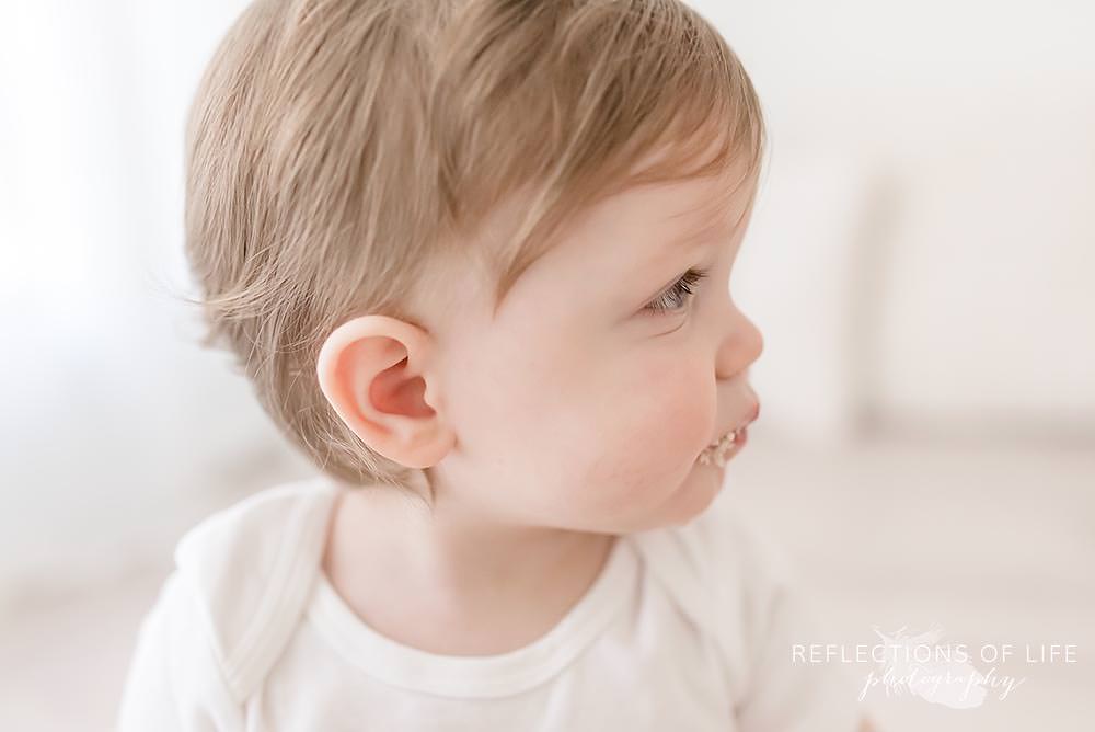profile of baby eating his cake