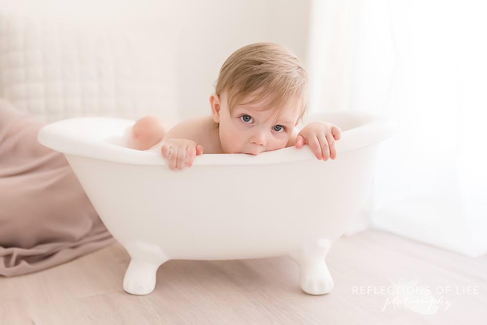 baby eats the side of the tub