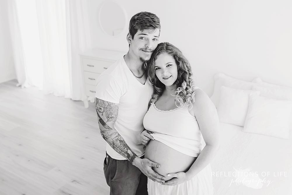 couple smiles at the camera in black and white