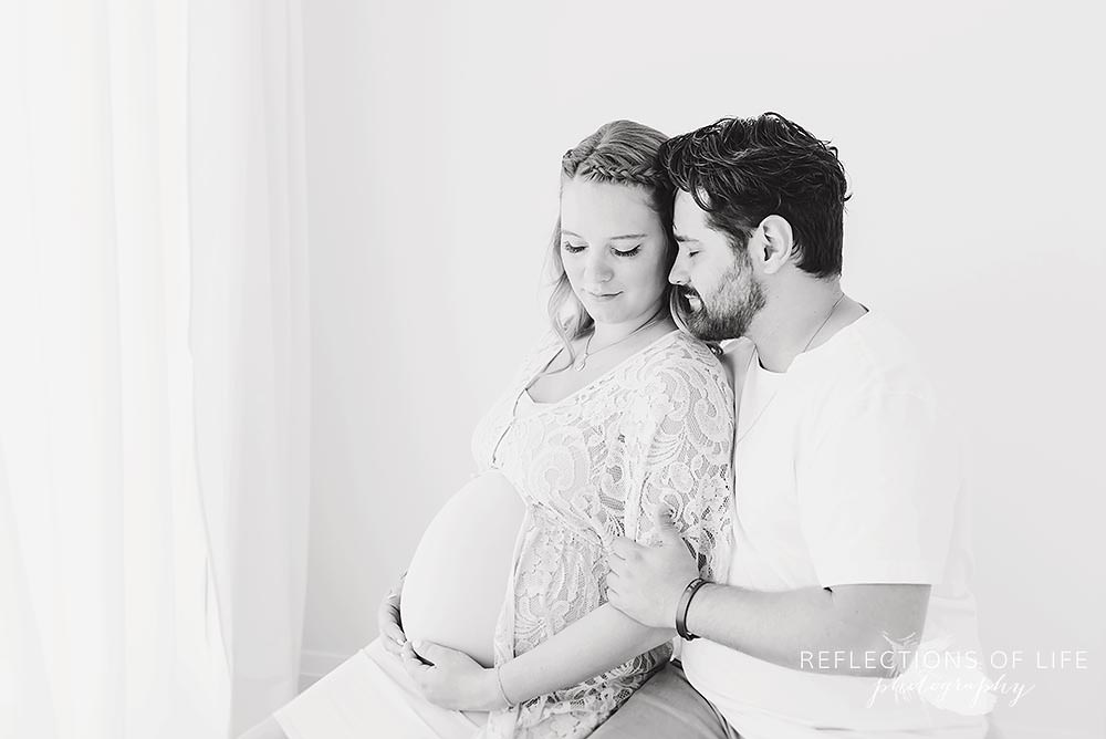 Pregnant couple in natural light studio thinking about the future Grimsby Ontario