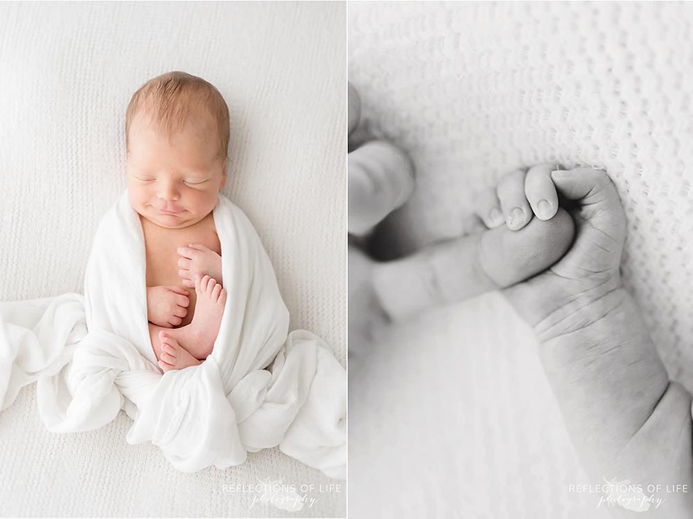Newborn baby wrapped up like an egg in little unicorn swaddle blanket and holding his dad's finger