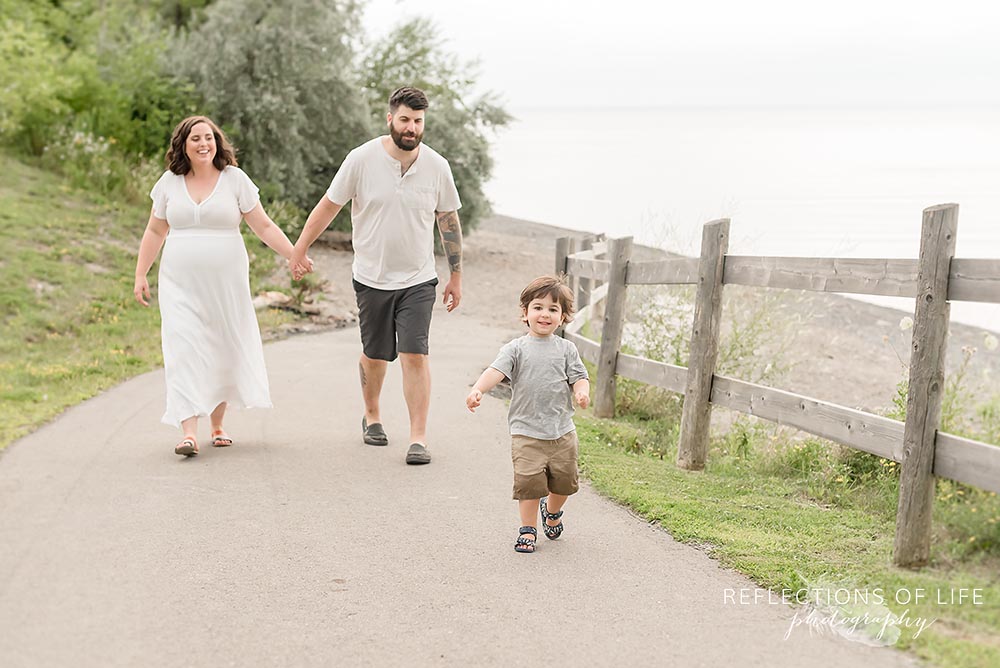 Little boy running on the path with his parents family photography Ontario.jpg