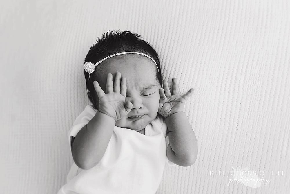 Newborn stretches out her hands in Burington Ontario natural light studio.jpg