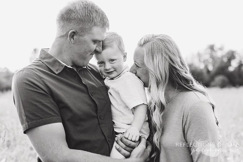 Cute little boy in the arms of his parents Niagara family photographer