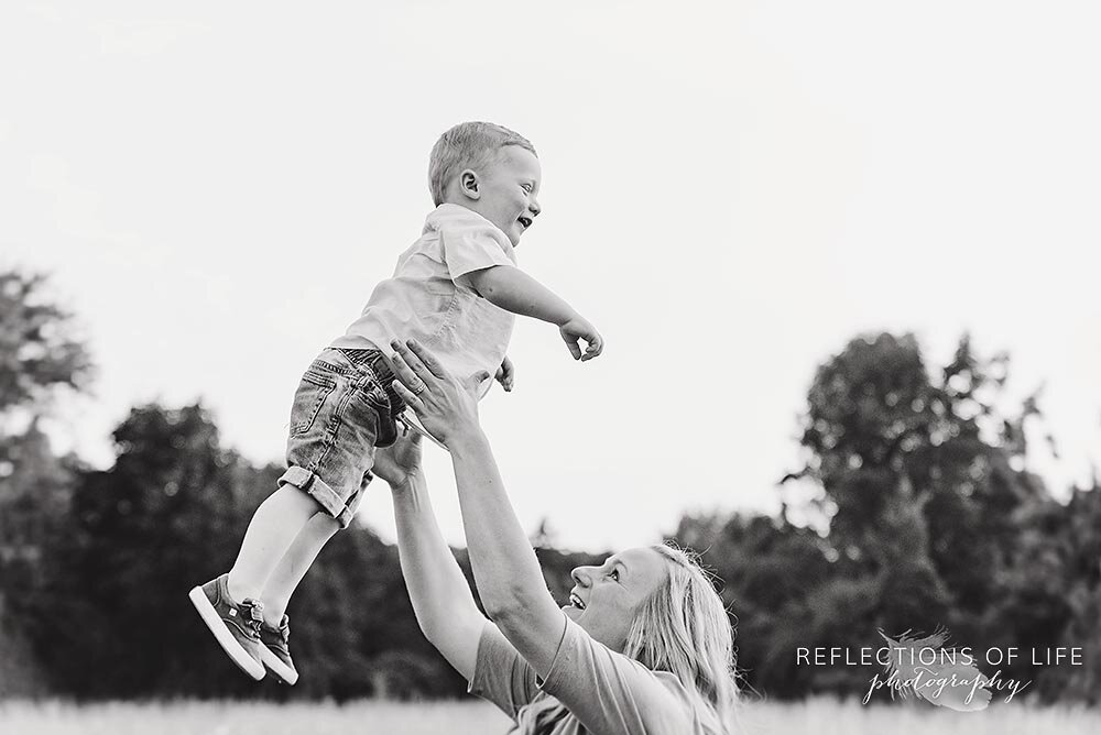 Mom throws her son into the air in natural light photos Grimsby Ontario