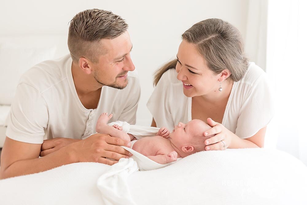New parents laughing with newborn baby girl.jpg