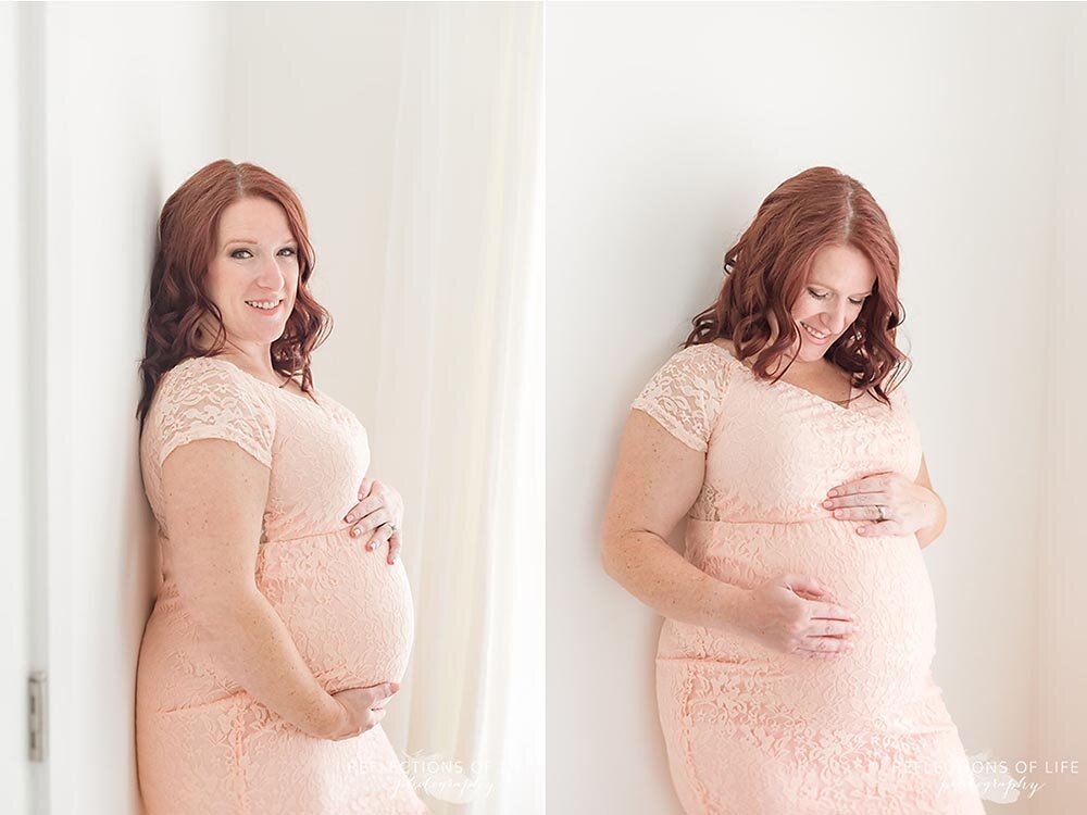 Redhead pregnant mom in pink dress posing in the windowlight