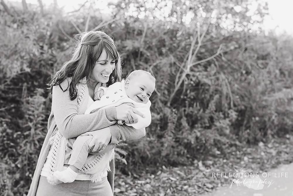 Mom and baby playing outdoors in black and white