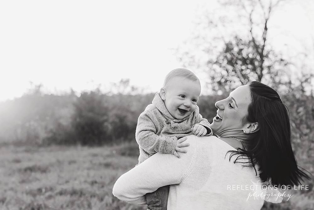 Mom twirls around with her son in her arms baby boy smiles.jpg