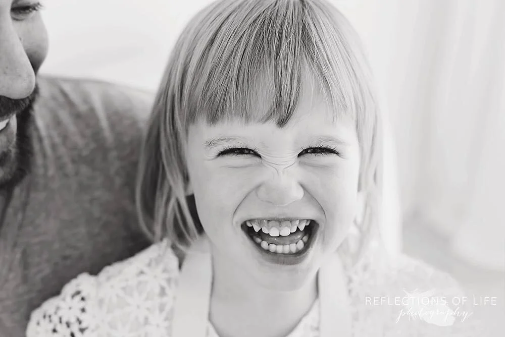 Little girl laughing in black and white