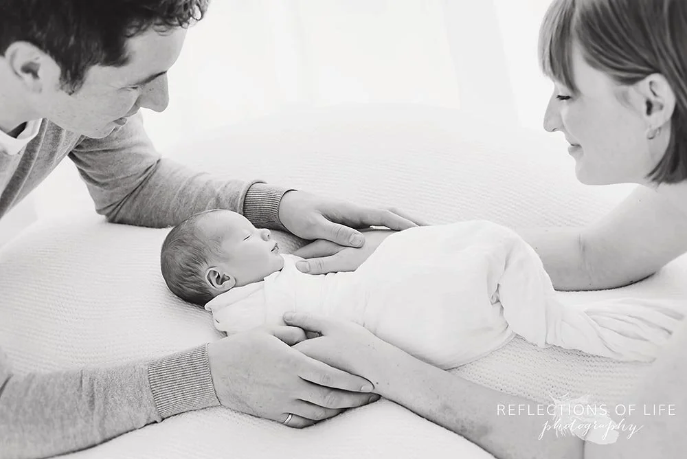 Parents Smiling Looking at Sleeping Newborn Toronto Ontario