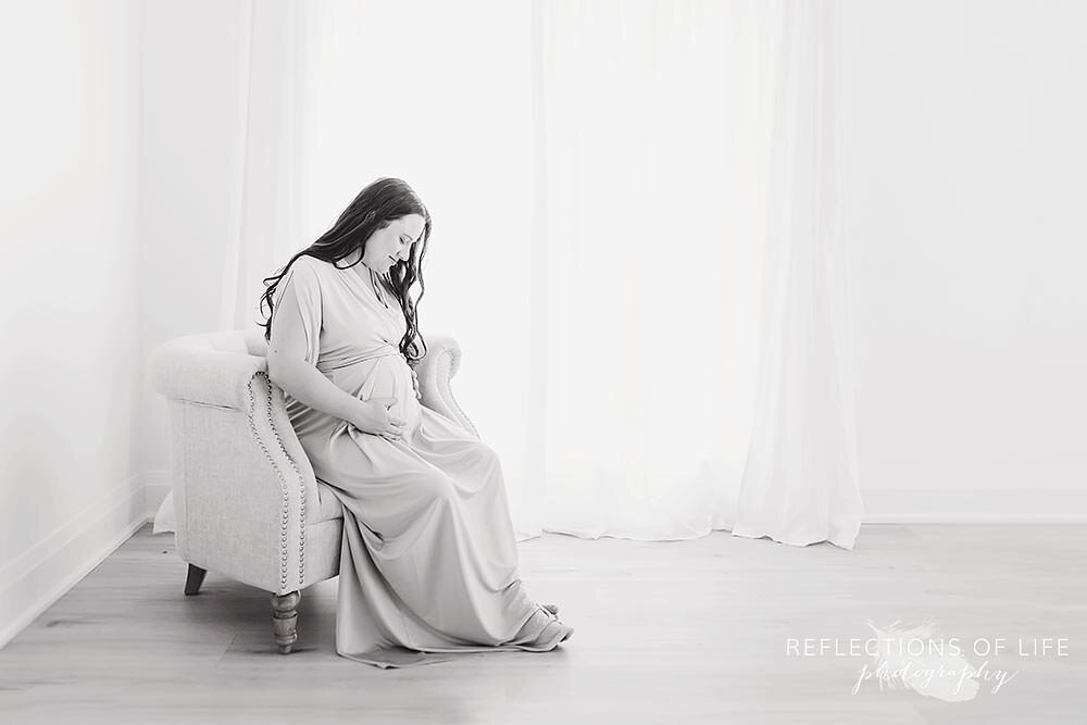 Mother Sitting In Chair Holding Pregnant Belly Niagara Falls Ontario