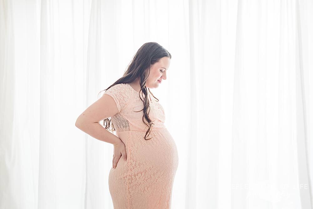 Pregnant Woman With Hands On Hips Looking Down 