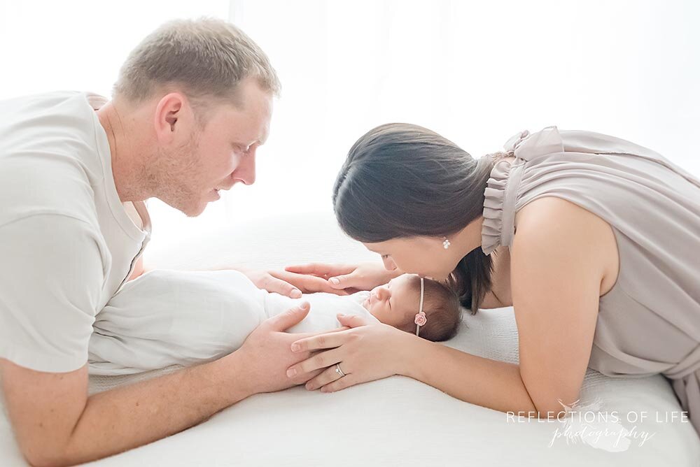 Newborn baby girl being kissed by her mama