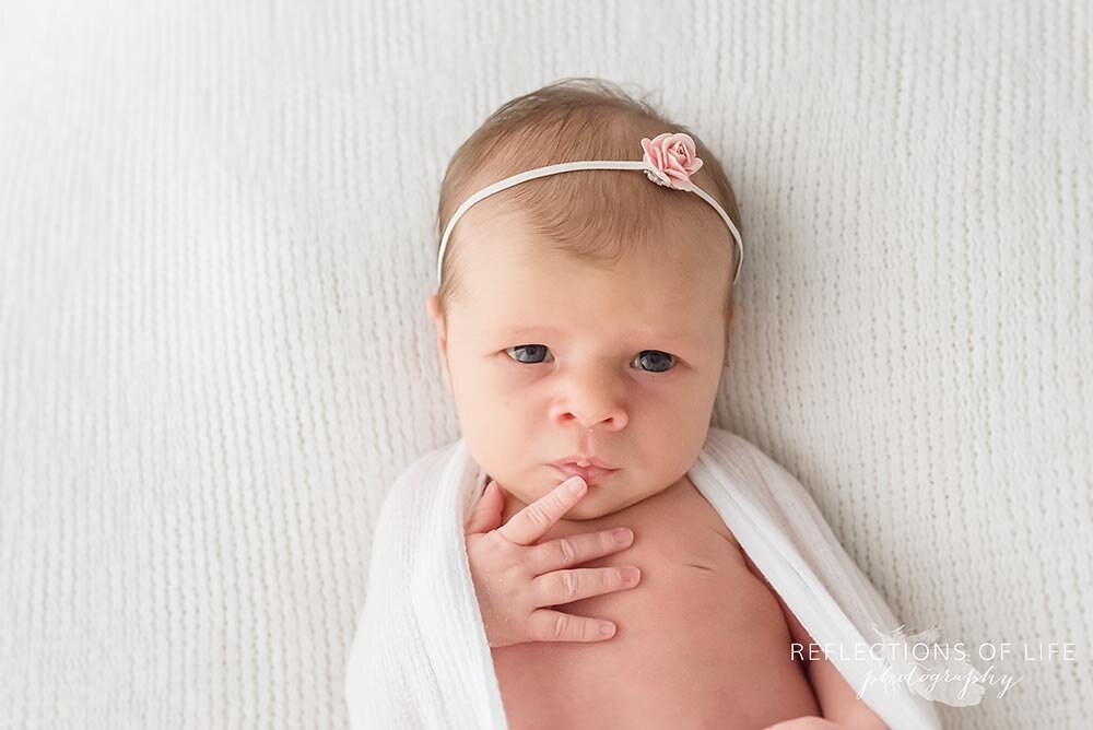 Newborn baby girl hands by her face Niagara Ontario natural light photo studi