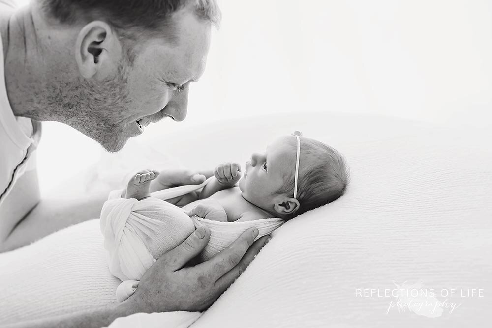 Daddy looks down at his beautiful newborn baby girl