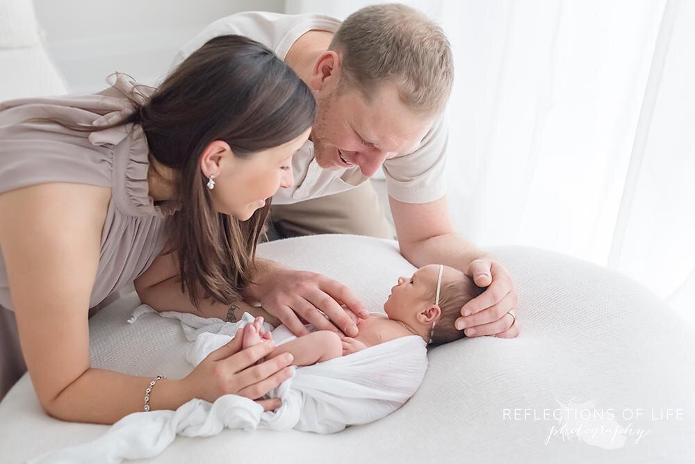 Newborn baby girl looks up at her loving parents Grimsby new baby photos