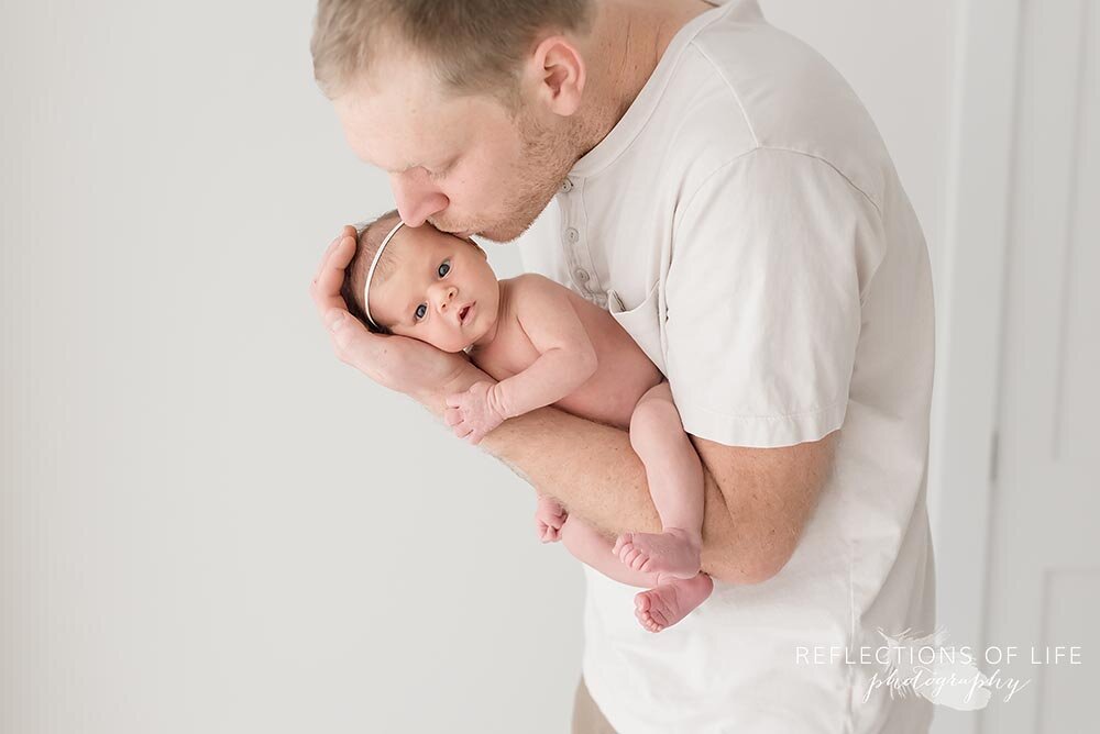 Daddy kissing new born baby girl on the head Southern Ontario Newborn Photographer