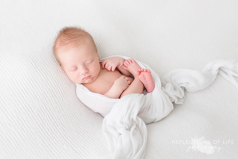 Newborn baby boy in white swaddle blanket Niagara Ontario Canada