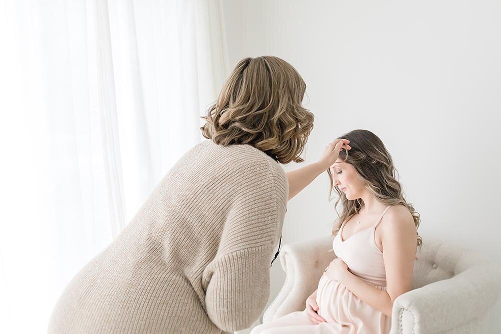 Hamilton maternity photographer fixing pregnant mamas hair during photo shoot (Copy)