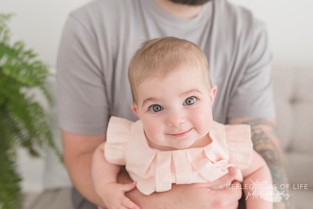 Little girl sitting on daddys lap Niagara Baby and Family Photographer in Ontario Canada