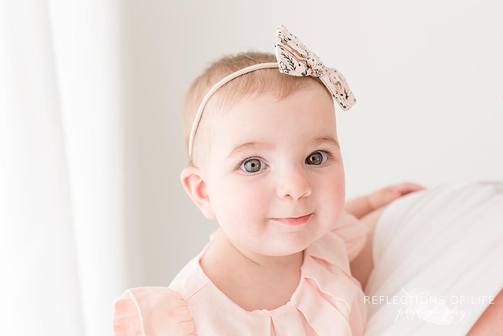 Adorable little girl in pink dress smiling at the camera Grimsby Ontario Photographer