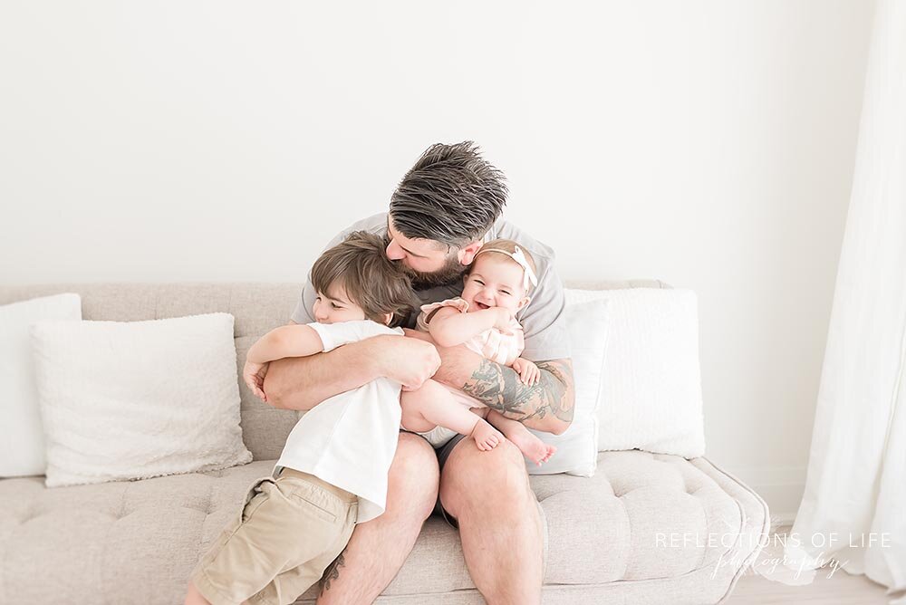 Daddy snuggling his two beautiful children Niagara Photography Studio