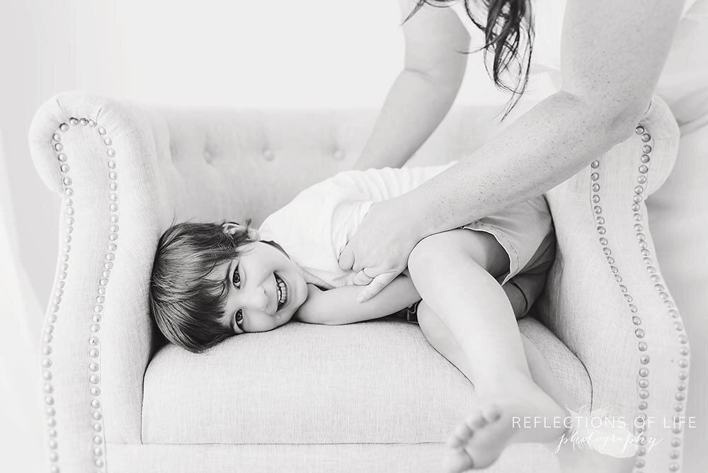 Little boy with his mothers arms tickling him black and white Niagara Professional Photographer