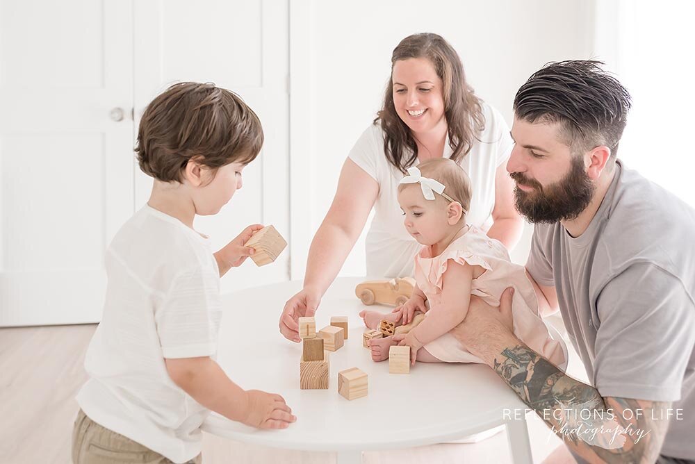 Family playing blocks together in a natural light studio