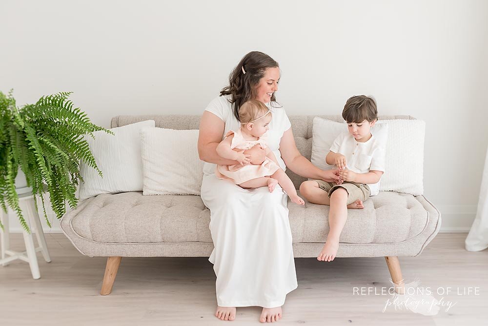 Mother playing with her two adorable kids in white studio Grimsby Ontario