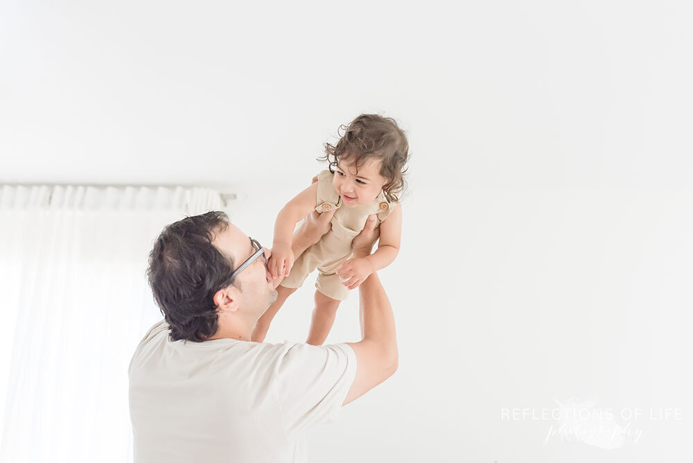 Daddy lifts his baby boy into the air in Grimsby Ontario Photo Studio