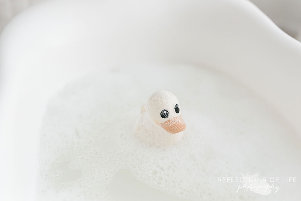 Baby bathtub with neutral rubber ducky in natural light studio Grimsby