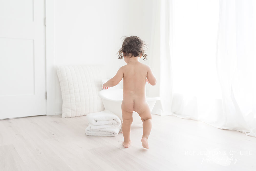  Baby boy walks toward his bubble bath in tiny bathtub Grimsby Ontario photoshoot