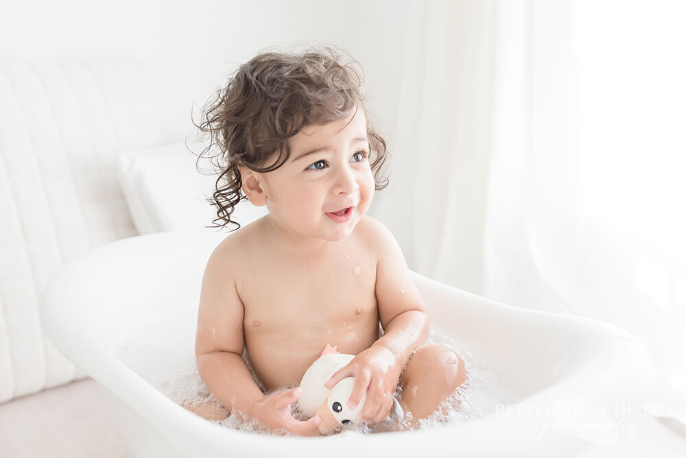 Baby bathtub photoshoot so cute boy smiling at his parents family photographer Grimsby Ontario