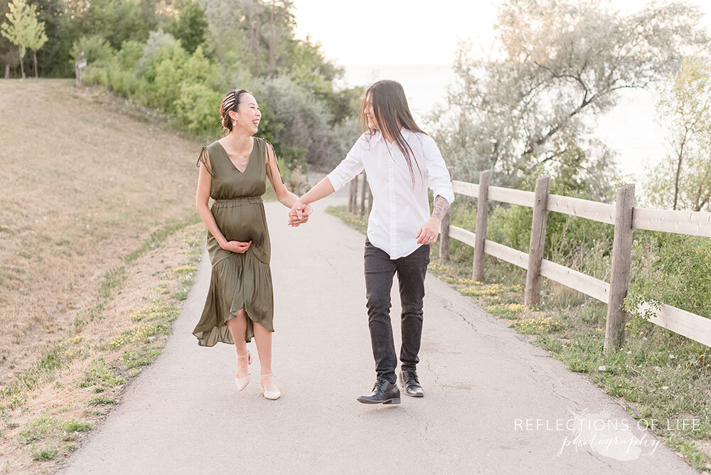 Pregnant couple walking down the path at Casablanca Beach in Grimsby Ontario Canada Natural maternity photographer