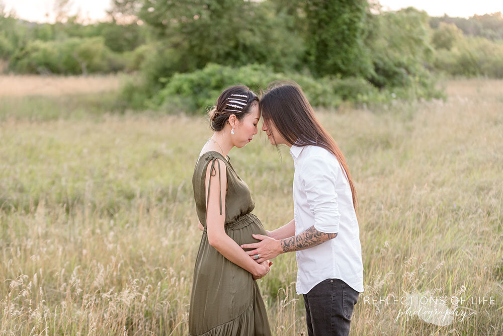 Pregnant couple leans into each other in the open field in Grimsby Ontario Canada Niagara Pregnancy Photographer