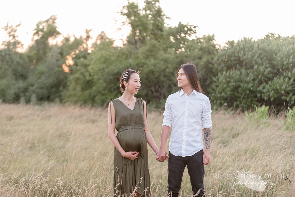 Pregnant couple looking at each other with love during Outdoor Pregnancy Photoshoot in Niagara Ontario Canada