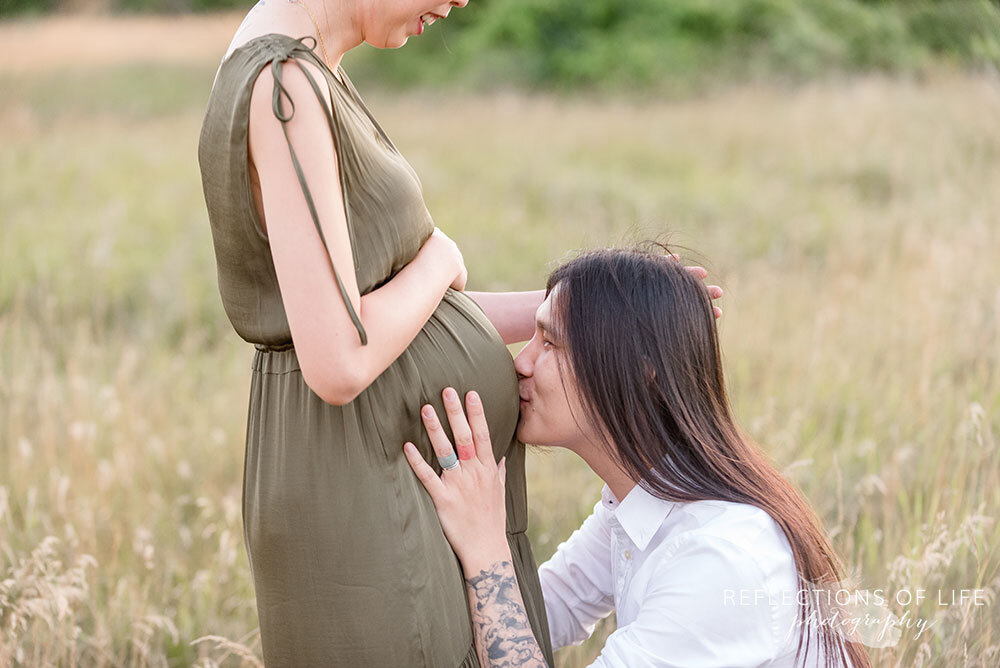 Happy soon-to-be daddy kissing his wife's belly Niagara Pregnancy Photography.jpg