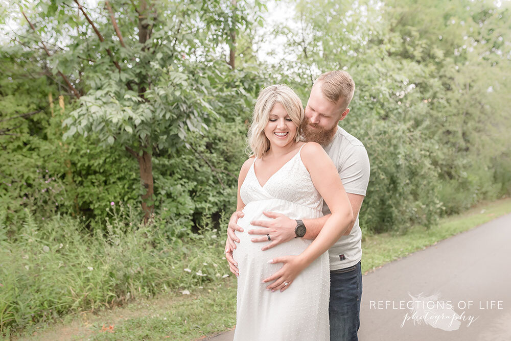 Niagara Maternity Photographer couple outdoors with their hands on mamas belly