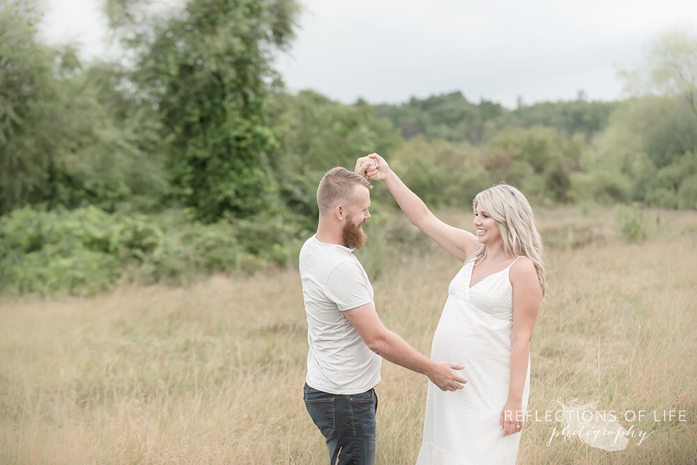 Pregnant couple dancing in the field beautiful maternity photography in Grimsby Ontario Canada