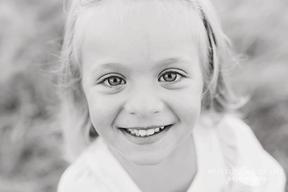 Outdoor closeup photo of little girl with gorgeous eyes in black and white