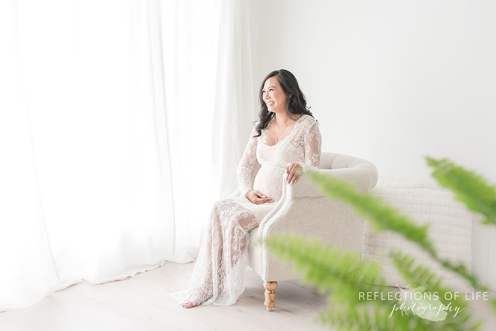 Grimsby Pregnancy Photography mama in white lace gown with green fern in studio