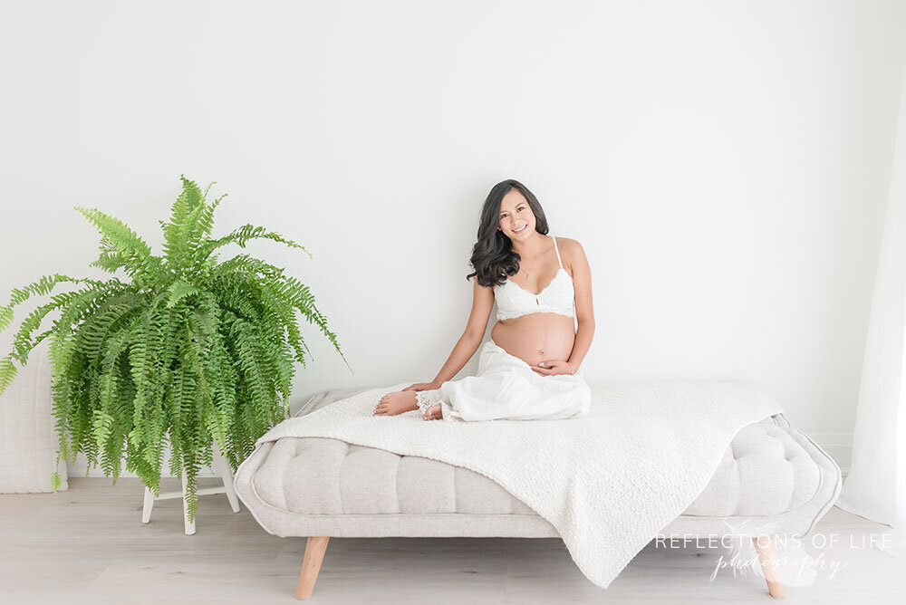 Gorgeous pregnancy portraits of beautiful mama in lace bralette and skirt with green fern