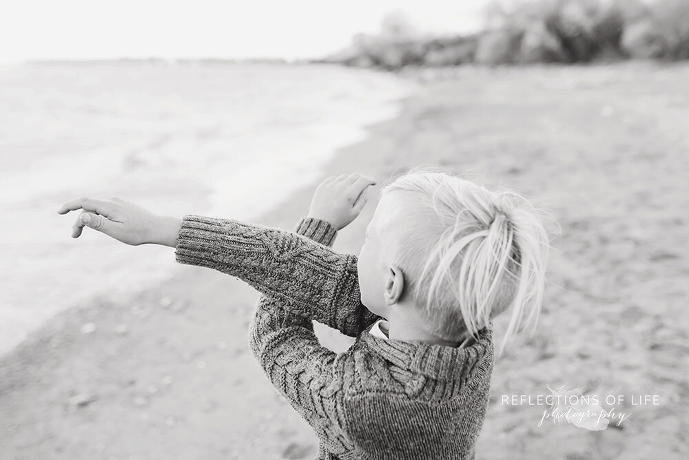 Child throwing rocks into Lake Ontario Niagar Region child photographer
