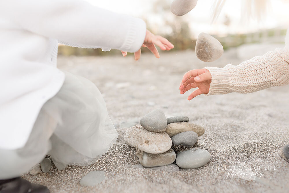 Sibling stacking rocks on the beach in Niagara Region Ontario